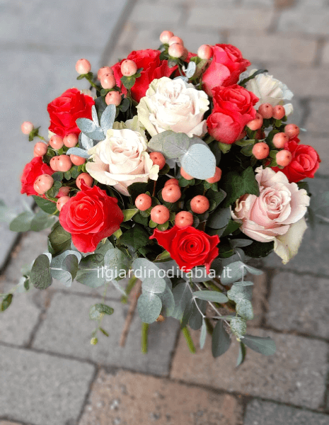 bouquet con mix di rose e complementi nei toni del rosso/rosa